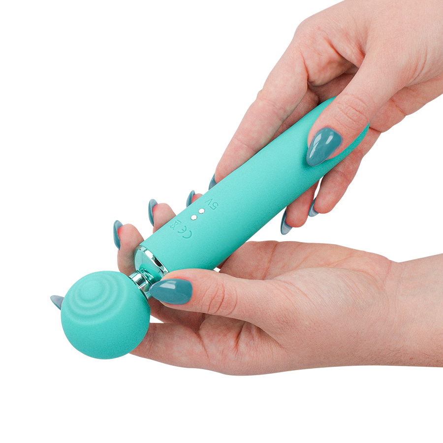 Hamby stimulateur multifonctionnel turquoise — tenu à deux mains, gros plan sur le marquage CE gravé sur le manche, ongles gris-vert