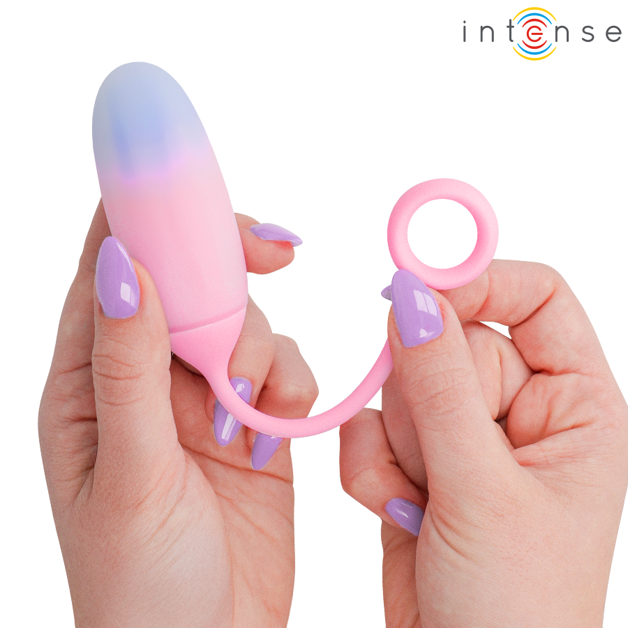 Pamela vibrateur dégradé bleu-rose — tenu à deux mains par le corps et l'anneau de préhension, ongles vernis lilas