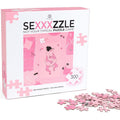 Jeu de casse-tête 'Sexxxzzle' — boîte de face avec illustration d'un couple enlacé et pièces de puzzle roses éparpillées devant