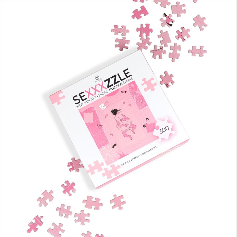 Jeu de casse-tête 'Sexxxzzle' — boîte posée en diagonale entourée de pièces de puzzle roses éparpillées