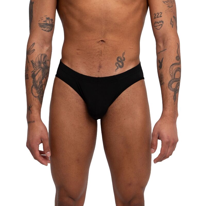 Slip noir uni vu de face, plan plus large incluant le buste et les bras tatoués du modèle.