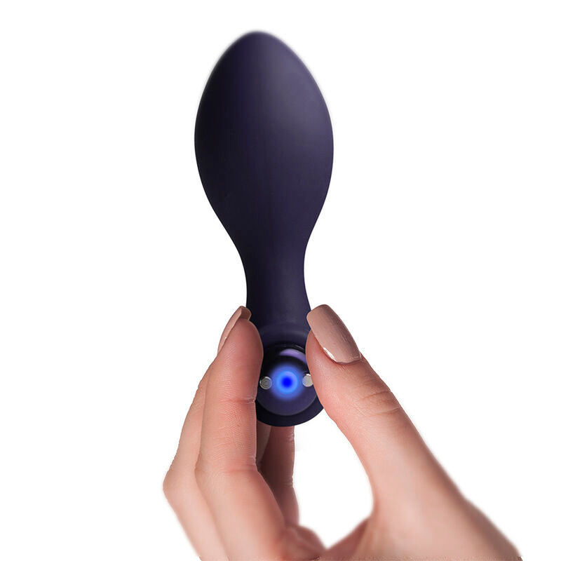 Nova Orbital posé à côté de son câble de recharge USB, vue de profil sur fond blanc