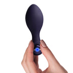 Nova Orbital posé à côté de son câble de recharge USB, vue de profil sur fond blanc