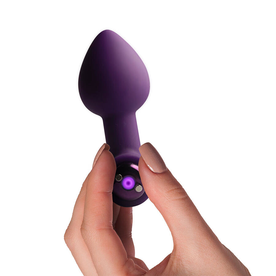 Plug vibrant Nova Astryx violet aubergine tenu en main, voyant lumineux allumé