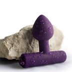 Plug vibrant Nova Astryx violet aubergine, gros plan mouillé posé contre une pierre