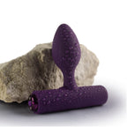 Plug vibrant Nova Solaris violet aubergine, gros plan mouillé posé contre une pierre