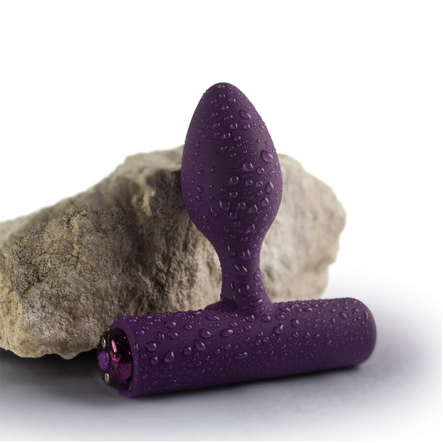 Plug vibrant Nova Solaris violet aubergine, gros plan mouillé posé contre une pierre