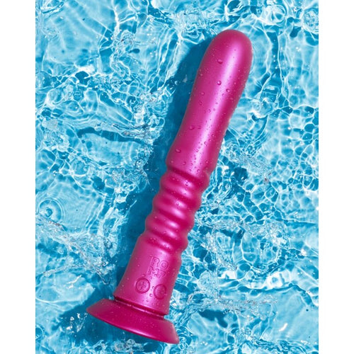 Vibromasseur a ventouse ROMP rose fuchsia en silicone pose sur fond aquatique, corps annele etanche et base ventouse pour la stimulation va-et-vient.