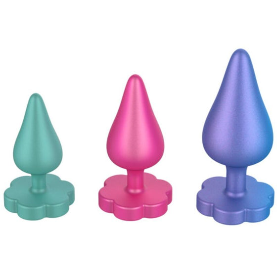 Trio de plugs anaux progressifs ROMP en silicone, modeles vert, rose et violet a base en forme de fleur, tailles croissantes pour une progression douce.