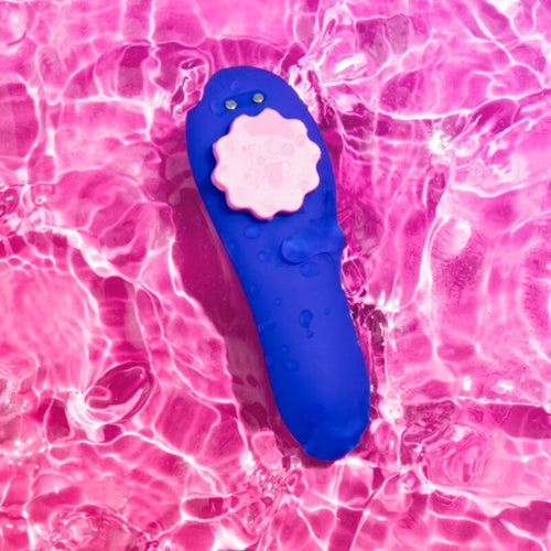 Module stimulateur de la culotte vibrante ROMP flottant sur une eau rose : coque bleue et fleur rose amovible, demonstration de l'etancheite waterproof de ce jouet portable discret.