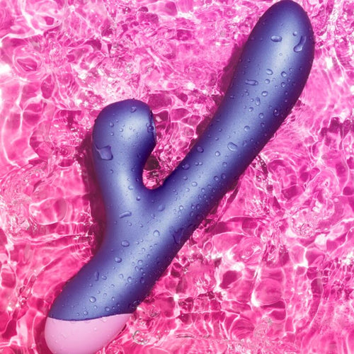 Vibromasseur lapin Reverb ROMP violet pose dans l'eau sur fond rose, mise en avant de l'etancheite et de la double stimulation point G et clitoris.