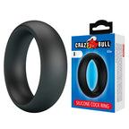 Anneau pénien Elio noir posé à côté de son emballage Crazy Bull Elio Silicone Cock Ring