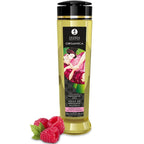 Flacon d'huile de massage Shunga Organica saveur framboise, avec des framboises fraîches posées devant