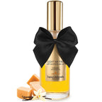 Huile de massage caramel sale Bijoux Indiscrets mise en scene avec caramels et gousse de vanille, flacon jaune a noeud satin, effet chaleur intensifiant les sensations.