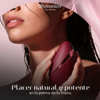 Femme tenant le Womanizer Next Liberty Bordeaux avec son capuchon, près de son cou.