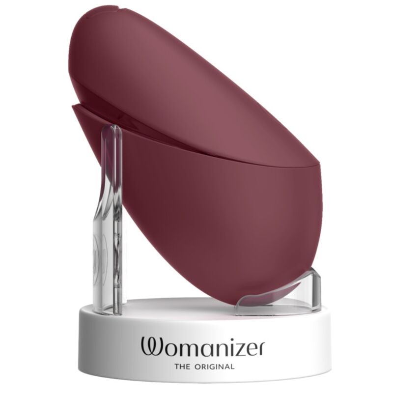 Womanizer Next Liberty Bordeaux fermé, présenté sur un support blanc de la marque.