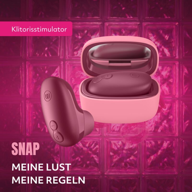 Womanizer Snap Baie écrasée et son étui rose ouvert avec miroir, sur des socles en verre rose.