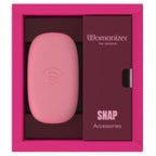 Coffret ouvert du Womanizer Snap Baie écrasée avec son étui rose et le compartiment d’accessoires.