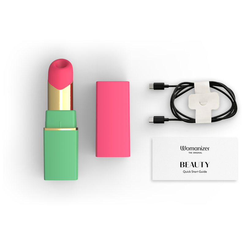 Womanizer Beauty vert et rose avec son capuchon, son câble de recharge et son guide.