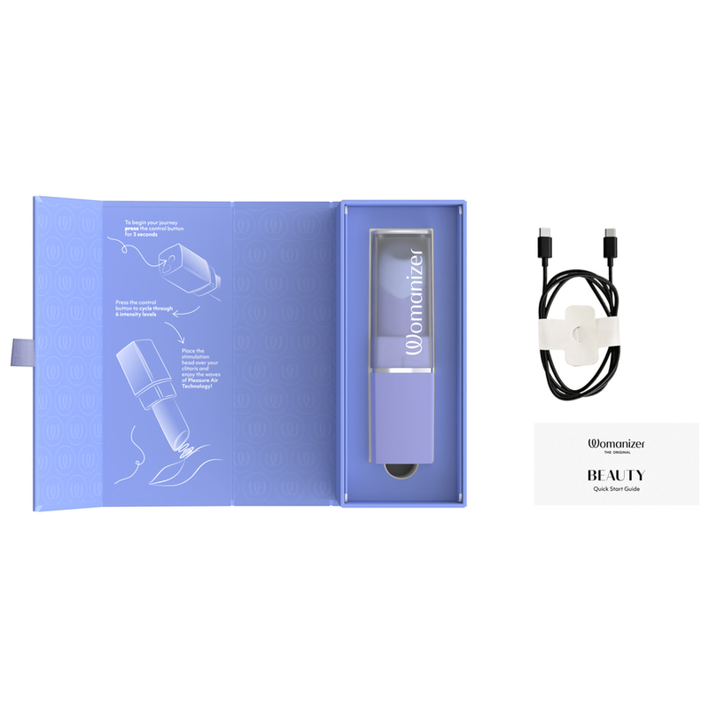 Coffret ouvert du Womanizer Beauty lilas avec son câble de recharge et son guide.