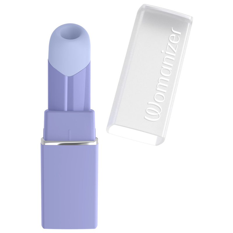 Womanizer Beauty lilas avec son capuchon transparent retiré et posé à côté.