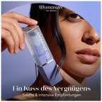 Femme tenant le Womanizer Beauty lilas près de son visage, avec son capuchon transparent fermé.