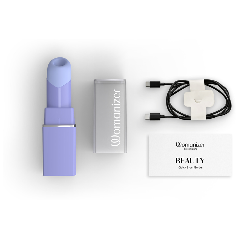 Womanizer Beauty lilas, capuchon transparent, câble de recharge et guide de démarrage.