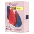 Boîte du Womanizer Next Liberty Rouge et Bleu vue de face, avec le stimulateur rouge et son capuchon bleu illustrés.