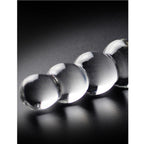 Gros plan artistique sur les perles graduees d'une baguette en verre transparent, billes lisses au diametre progressif pour une stimulation tout en douceur.