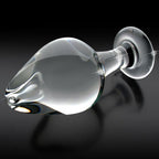 Plug en verre transparent souffle main pose a plat sur fond noir, tete bulbeuse, col etroit et base anneau, surface lisse non poreuse facile a entretenir.