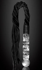Gros plan sur la poignee en verre souffle torsade du fouet et le depart de ses lanieres noires, manche lisse non poreux pour un jeu de discipline elegant.