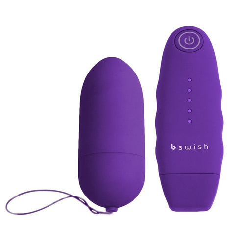 Œuf vibrant violet à cordon de récupération à gauche, télécommande violette bswish à droite. Forme bullet lisse, surface satinée, ensemble télécommandé pour stimulation externe.