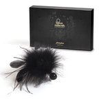 Plumeau Pom Pom noir aux fibres douces présenté avec son étui noir et doré Bijoux Indiscrets, accessoire de stimulation sensorielle léger et sans électronique.