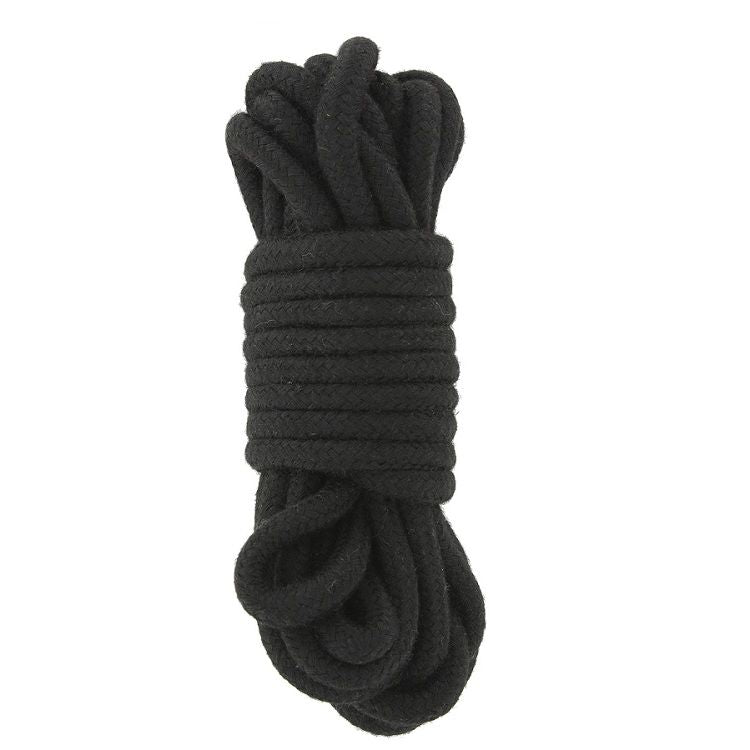 Corde de bondage shibari en coton noir enroulee, accessoire d'attache souple du kit BDSM initiation couple, gros plan sur le cordage tresse