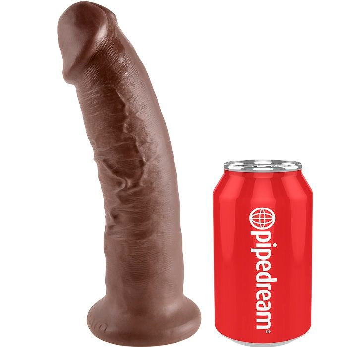 Gode realiste King Cock marron incline a coté d'une canette Pipedream rouge pour l'echelle de taille, gland et veines nets, base ventouse, grand format, modele fait main effet peau mat.
