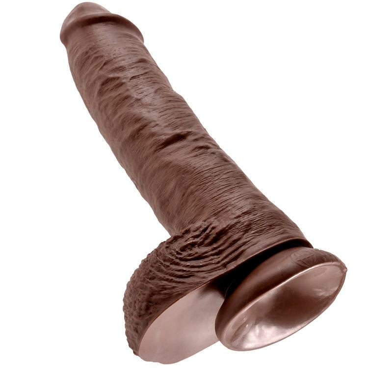 Gode King Cock teinte chocolat courbé, gland charnu et testicules moulés volumineux, fût veiné réaliste, base ventouse, vue trois quarts sur blanc.