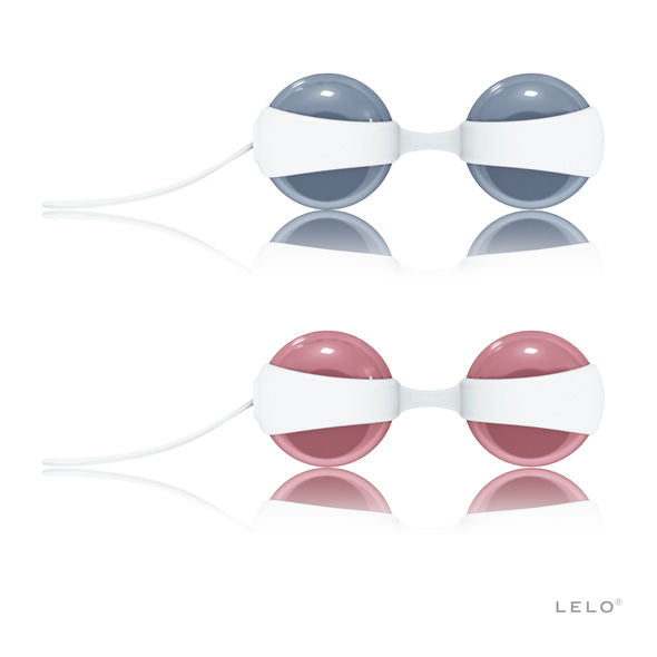Deux paires de boules de geisha Luna Beads de Lelo dans leurs coques blanches, sphères grises et roses interchangeables avec cordons, set de tonification.