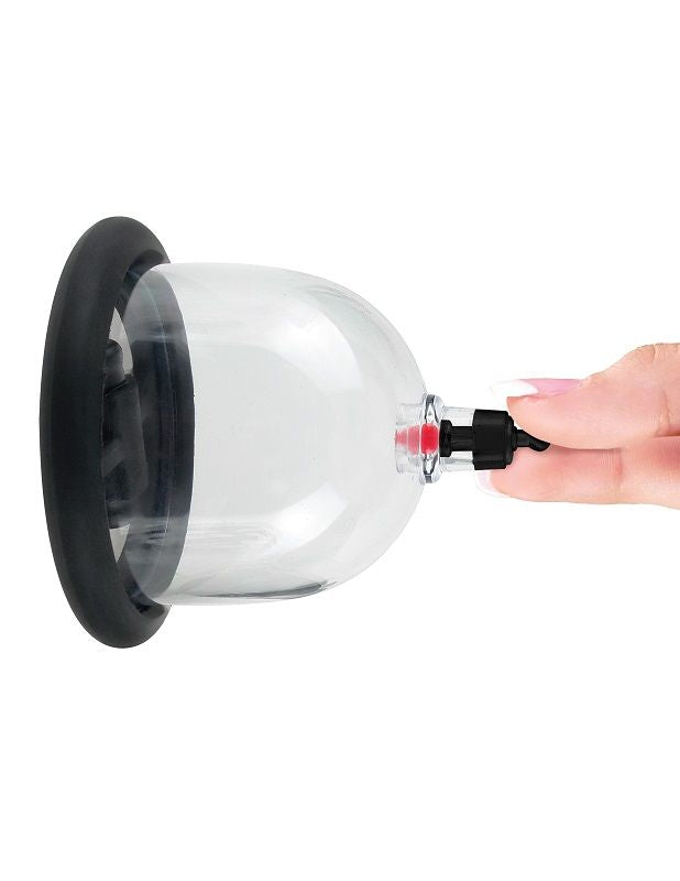 Ventouse de stimulation transparente a embout noir tenue entre les doigts, gros plan de l'accessoire de cupping a succion reglable sans element anatomique.