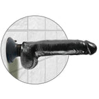 Grand gode a testicules King Cock noir fixe par ventouse sur un mur carrele, tige realiste veinee et bourses a l'horizontale pour un usage mains libres sous la douche.
