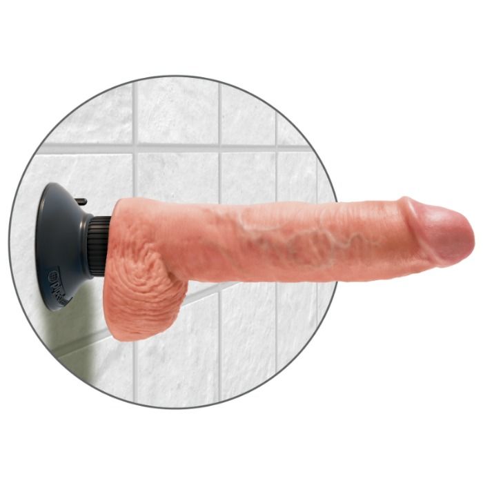 Tres grand gode a testicules King Cock fixe par ventouse sur un mur carrele, longue tige realiste veinee couleur peau a l'horizontale pour un usage mains libres.