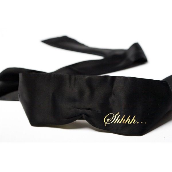 Masque en ruban de satin noir avec message Shhh doré et longues bandes à nouer, bandeau sensuel Bijoux Indiscrets pour aiguiser le toucher et l'écoute à deux.