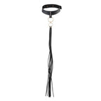 Choker pompon noir Bijoux Indiscrets en polyurethane vegan transformable en fouet, presente a plat, collier a franges et anneau a double usage mode et soft bondage.