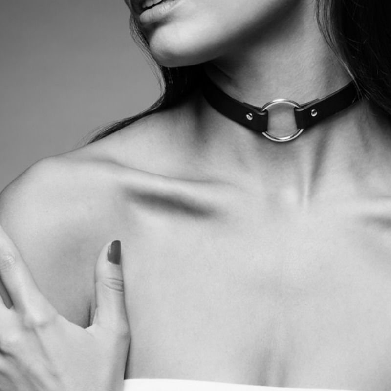 Modele portant le collier ras de cou noir Bijoux Indiscrets a anneau argente, mise en scene epuree noir et blanc mettant en valeur l'accessoire BDSM chic et reglable.