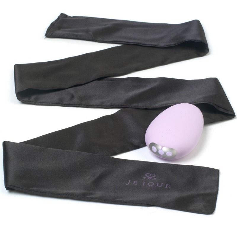 Vibromasseur Mimi Soft lilas posé sur un long bandeau de satin noir déroulé, galet lisse et accessoire bien-être présentés ensemble en mise en scène sur fond blanc parfaitement épuré.