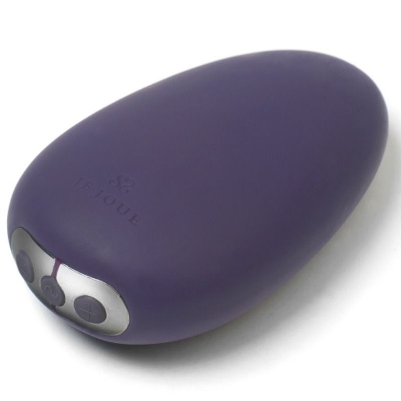 Gros plan du galet Mimi Soft violet de trois quarts, commandes argentées et liseré rose visibles, texture silicone douce, objet arrondi compact et non figuratif.