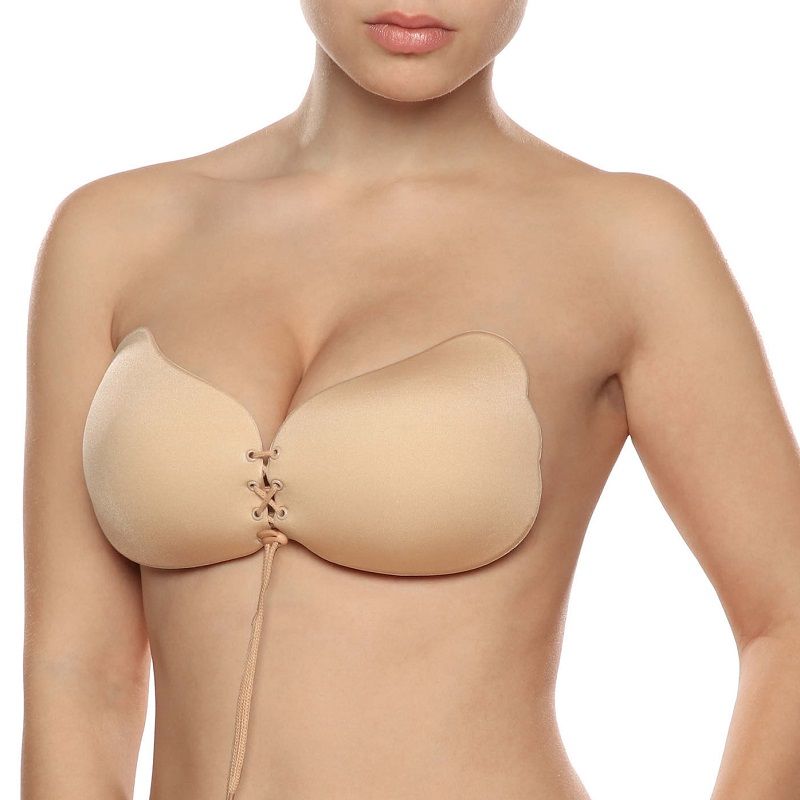 Soutien-gorge adhesif Lace-it beige porte de face sur buste nu, coupelles push-up a lacage avant resserrant la poitrine pour un effet decollete galbe et rehausse.
