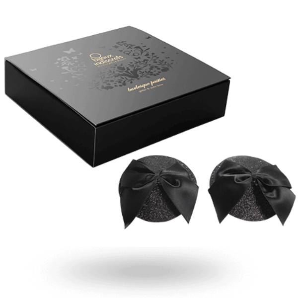 Coffret noir des cache-tétons burlesques avec la paire pailletée à nœud posée devant, accessoire de poitrine adhésif et réutilisable signé Bijoux Indiscrets.