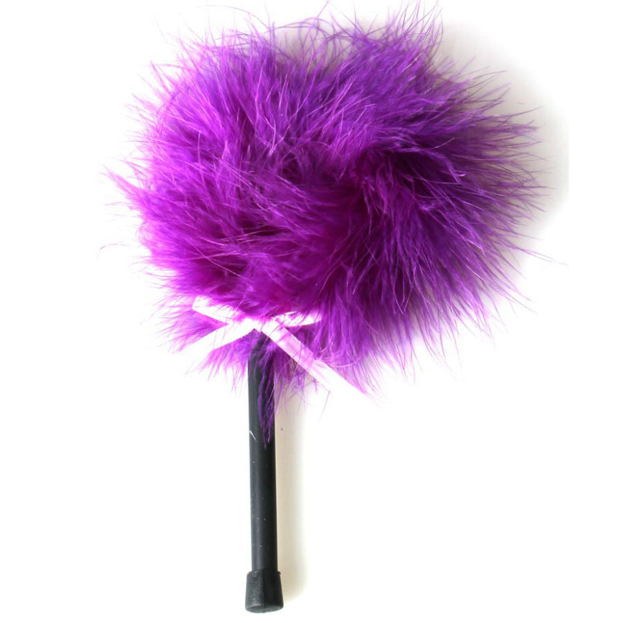 Plumeau tickler Secret Play, large pompon de plumes violettes moelleuses sur manche noir avec ruban, accessoire sensoriel pour caresses legeres et exploration du corps a deux.