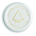 Couvercle blanc du baume clitoridien Fire du coffret horoscope Bijoux Indiscrets, mention Clitoral Arousal Balm et triangle dore, cosmetique stimulant sur fond blanc