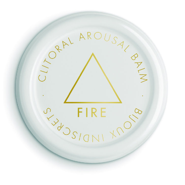 Couvercle blanc du baume clitoridien Fire du coffret horoscope Bijoux Indiscrets, mention Clitoral Arousal Balm et triangle dore, cosmetique stimulant sur fond blanc